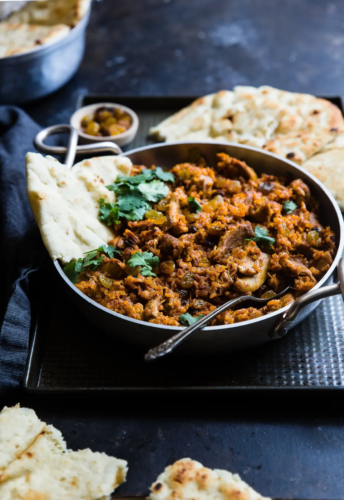 Aromatic curry served in a balti dish with naan and papadom
